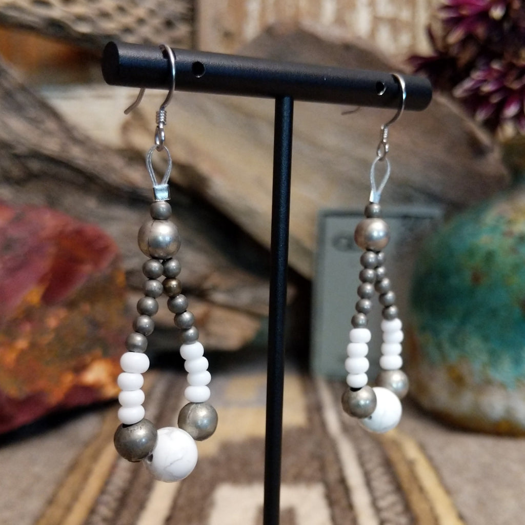 A pair teardrop earrings, featuring a mix of silver and white beads with a central white stone.