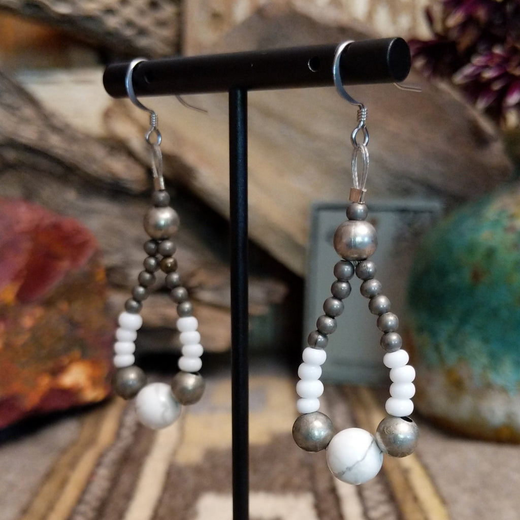 A pair teardrop earrings, featuring a mix of silver and white beads with a central white stone.