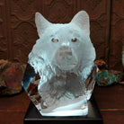 A clear Lucite sculpture featuring two hand-painted wolves with a frosted wolf's face emerging in the background, symbolizing loyalty and family; lower light display.