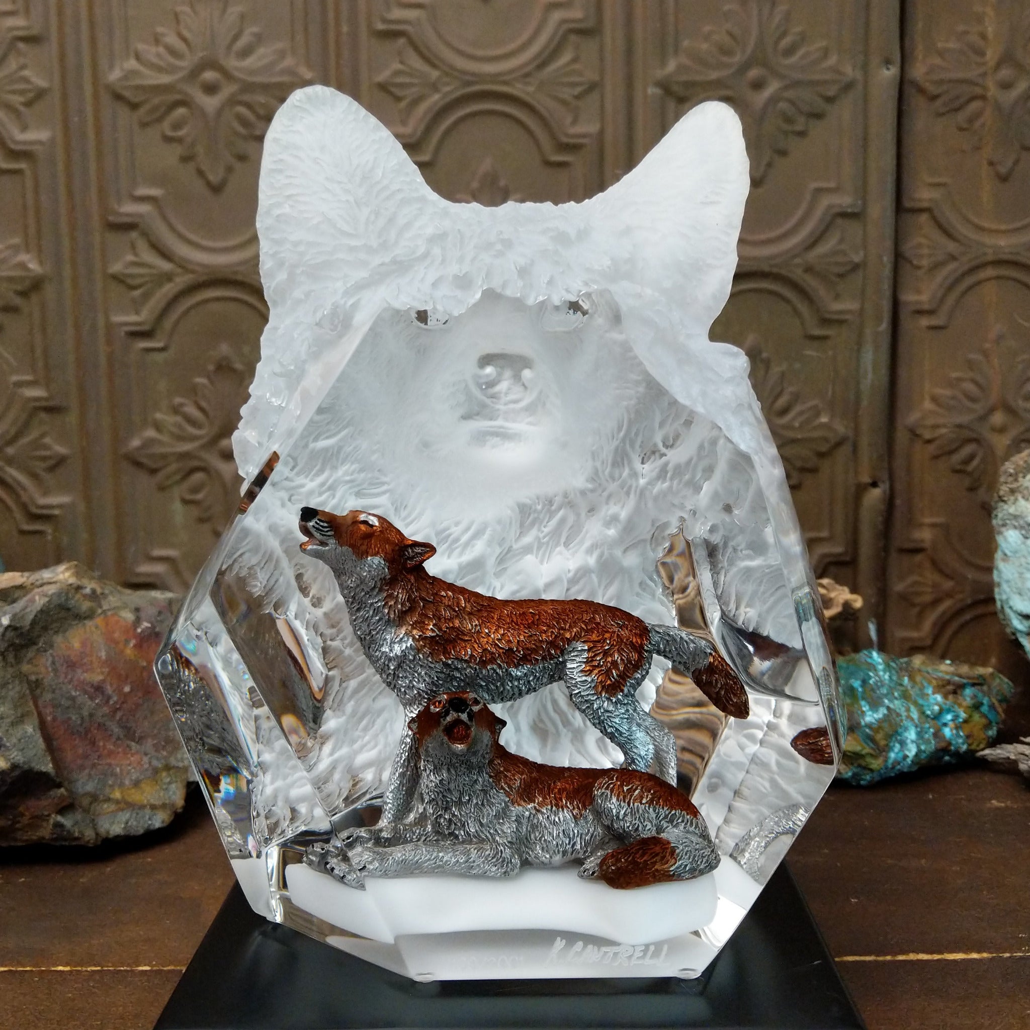 A clear Lucite sculpture featuring two hand-painted wolves with a frosted wolf's face emerging in the background, symbolizing loyalty and family.