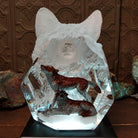 A clear Lucite sculpture featuring two hand-painted wolves with a frosted wolf's face emerging in the background, symbolizing loyalty and family; lower light display.