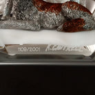 A clear Lucite sculpture featuring two hand-painted wolves with a frosted wolf's face emerging in the background, symbolizing loyalty and family; artisan signature and production number.