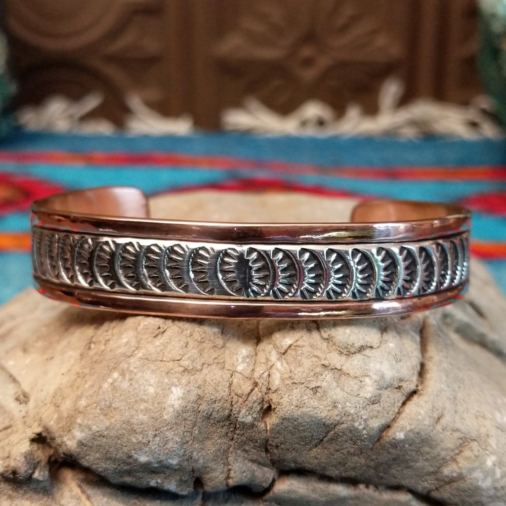 Copper and sterling silver cuff with grass stamping and polished finish.