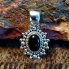 Sterling silver and black onyx pendant framed by dotted accents and a twisted rope design.