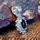 Sterling silver and black onyx pendant framed by dotted accents and a twisted rope design.