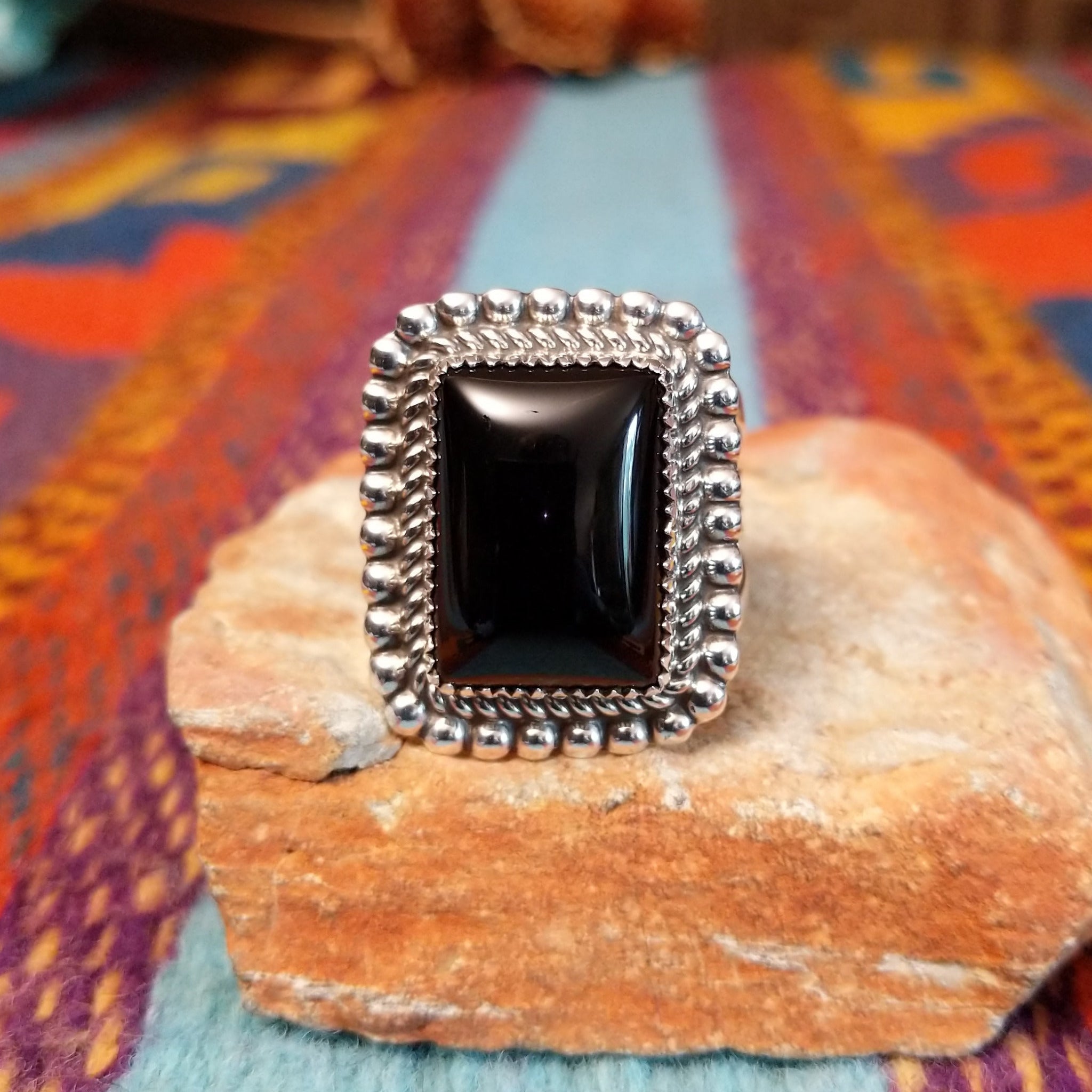 Dotted Black Onyx Ring by Alvin Joe featuring a large polished rectangular black onyx stone framed by twisted silver rope and a border of raised silver beads.