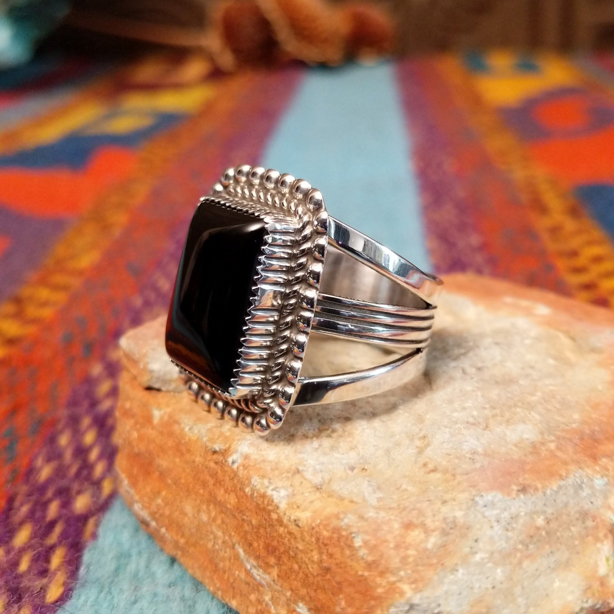 Dotted Black Onyx Ring by Alvin Joe featuring a large polished rectangular black onyx stone framed by twisted silver rope and a border of raised silver beads; side view.