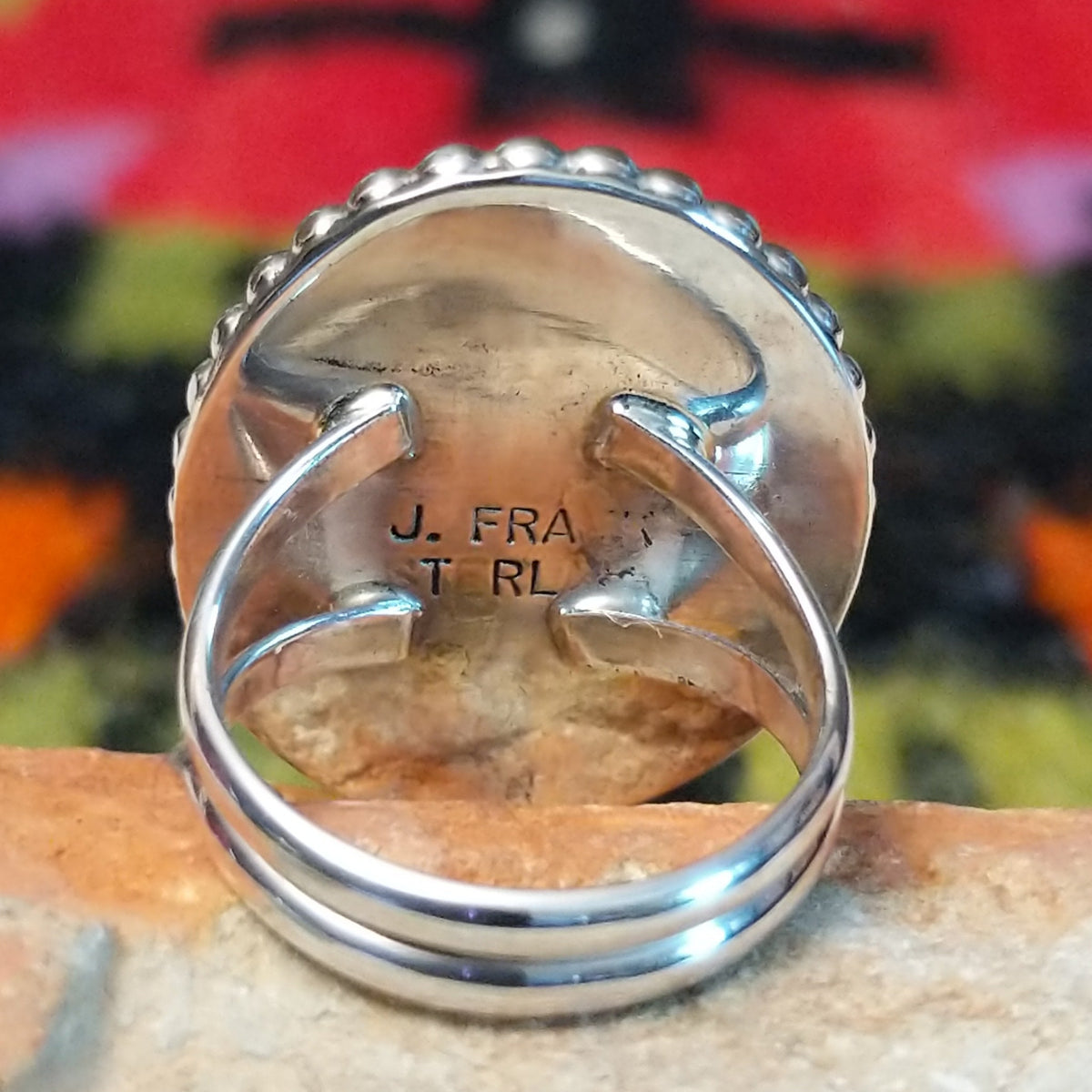 This Black Onyx Ring by J. Frank features a large oval black onyx stone set in sterling silver with twisted rope detailing and a raised beaded border; artisan and Sterling Silver stamp.
