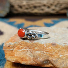 Handcrafted sterling silver dotted coral ring by Lowell Draper, featuring an oval coral cabochon with polished silver bead accents; side view.