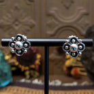 Sterling silver floral stud earrings by Navajo artist Artie Yellowhorse featuring polished silver beadwork and oxidized flower details.