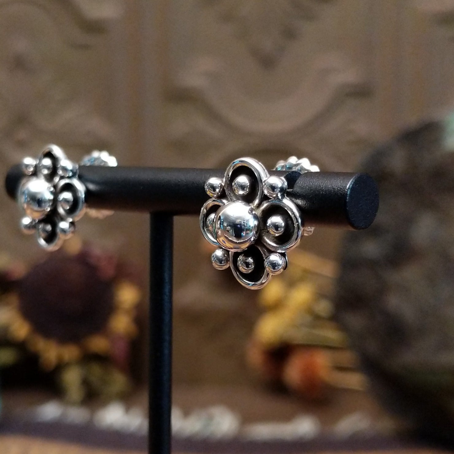 Sterling silver floral stud earrings by Navajo artist Artie Yellowhorse featuring polished silver beadwork and oxidized flower details.
