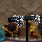 Sterling silver floral stud earrings by Navajo artist Artie Yellowhorse featuring polished silver beadwork and oxidized flower details.