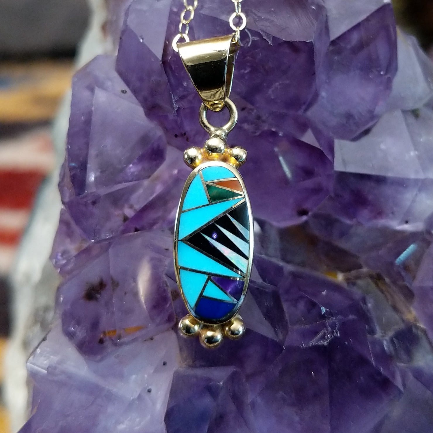 14kt gold Steve Francisco oval multistone pendant with geometric inlay and gold bead accents.