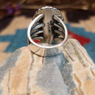 Sterling silver ring with Sonoran gold turquoise set in a large, oval bezel that is framed by dotted accents.