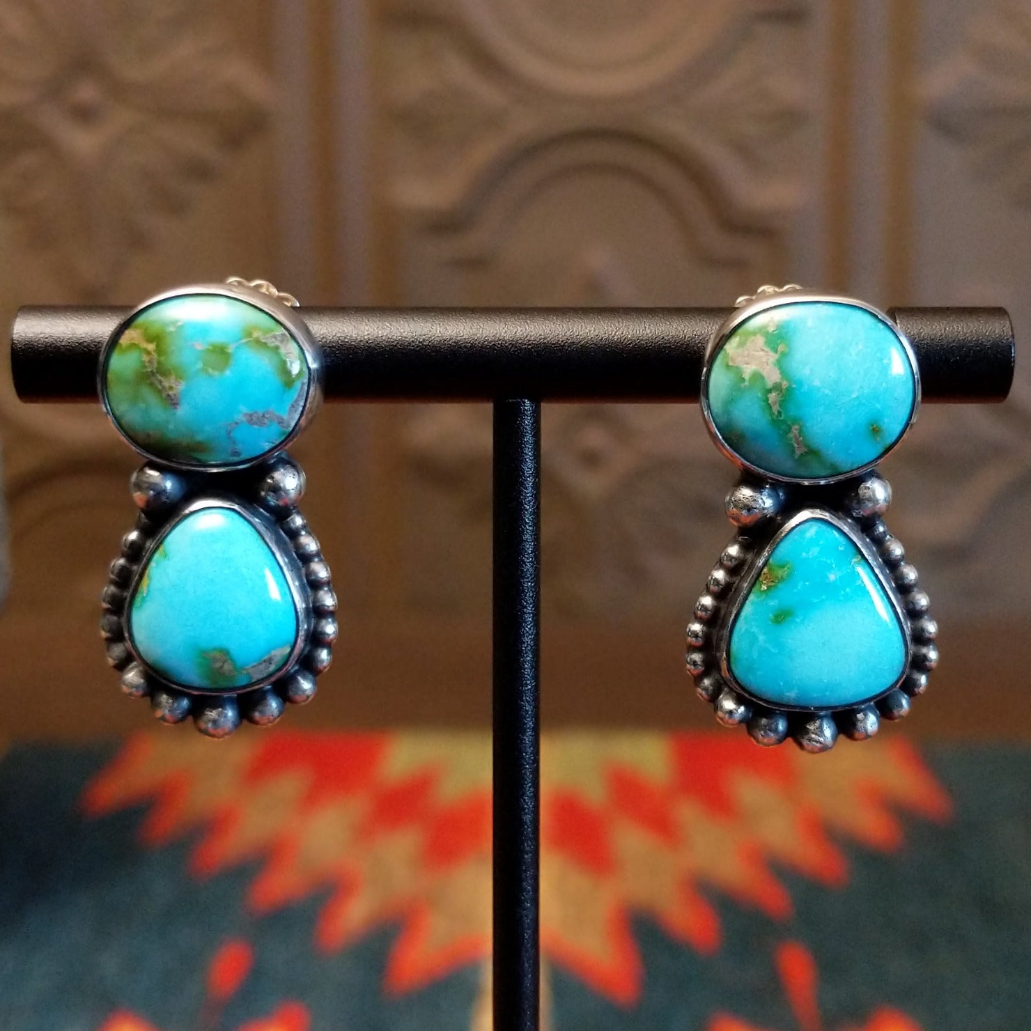 Earrings with Sonoran Mountain turquoise set in bezels, framed by dotted accents. 