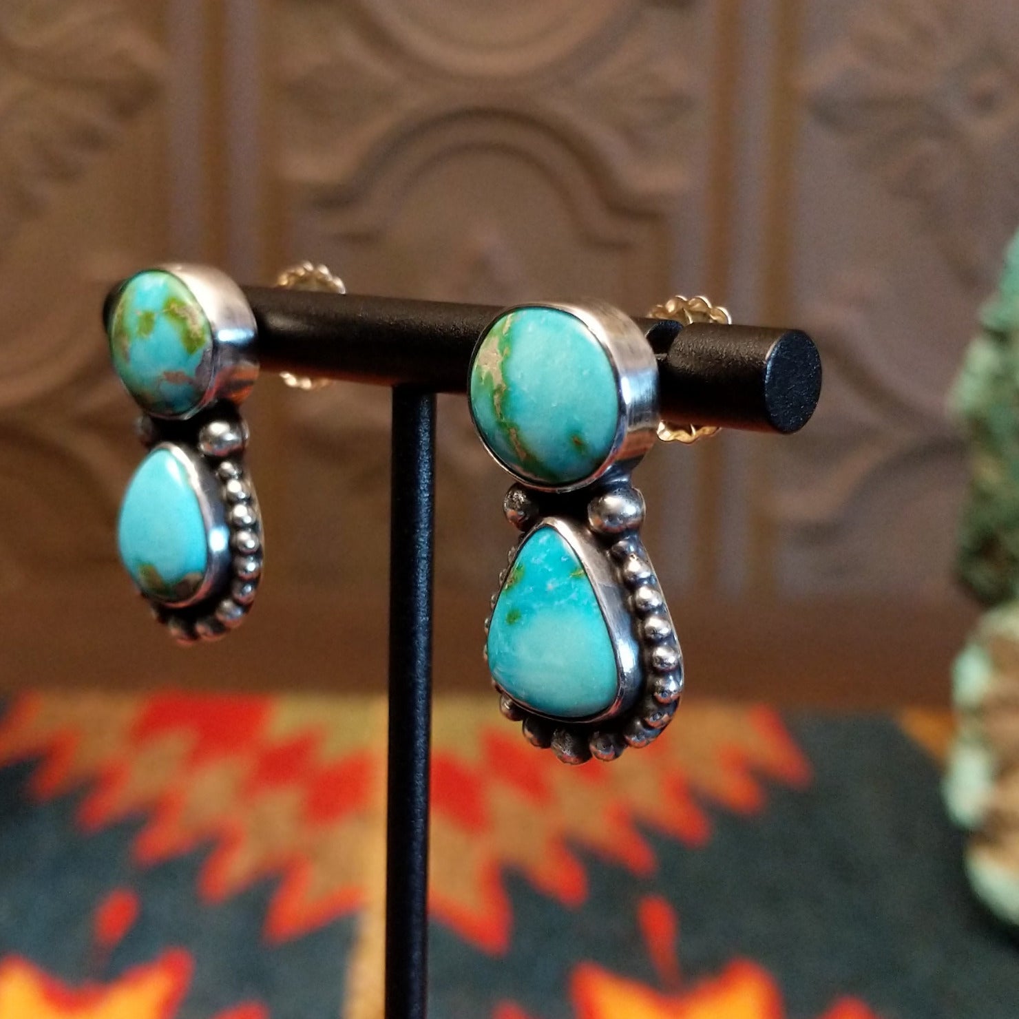 Earrings with Sonoran Mountain turquoise set in bezels, framed by dotted accents. 