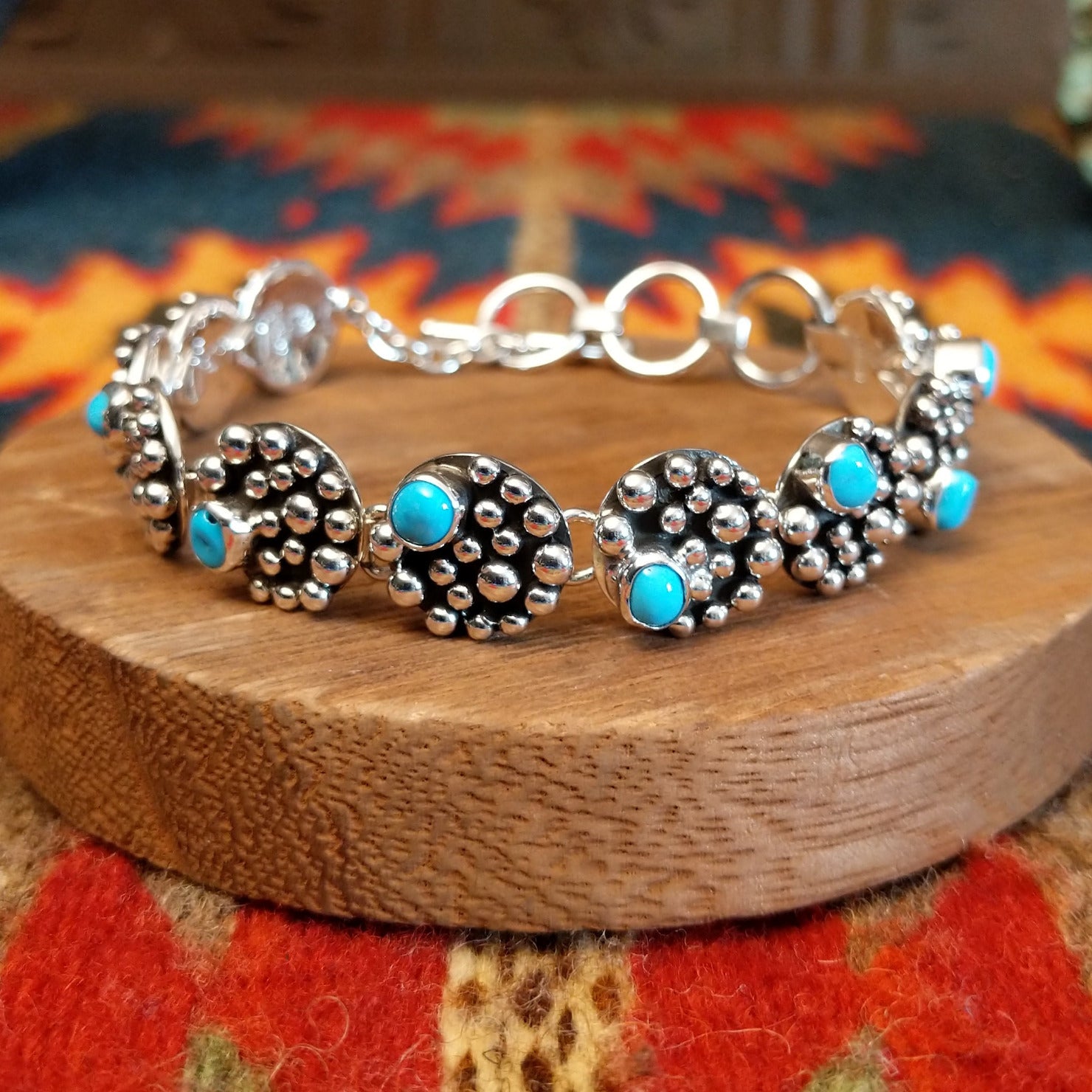 Sterling silver bracelet with dotted settings and turquoise set in small, round bezels.