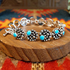 Sterling silver bracelet with dotted settings and turquoise set in small, round bezels.