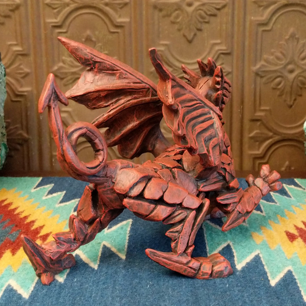 Cast marble made into a dragon sculpture and painted reddish-orange.