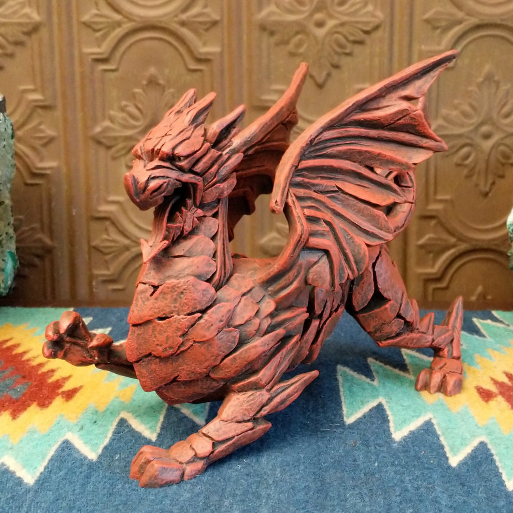 Cast marble made into a dragon sculpture and painted reddish-orange.
