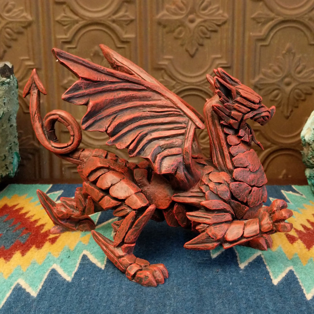 Cast marble made into a dragon sculpture and painted reddish-orange.