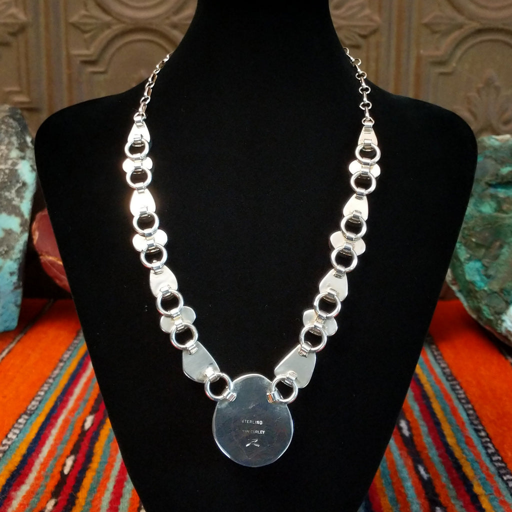 Artisan's signature stamped into the largest necklace pendant.