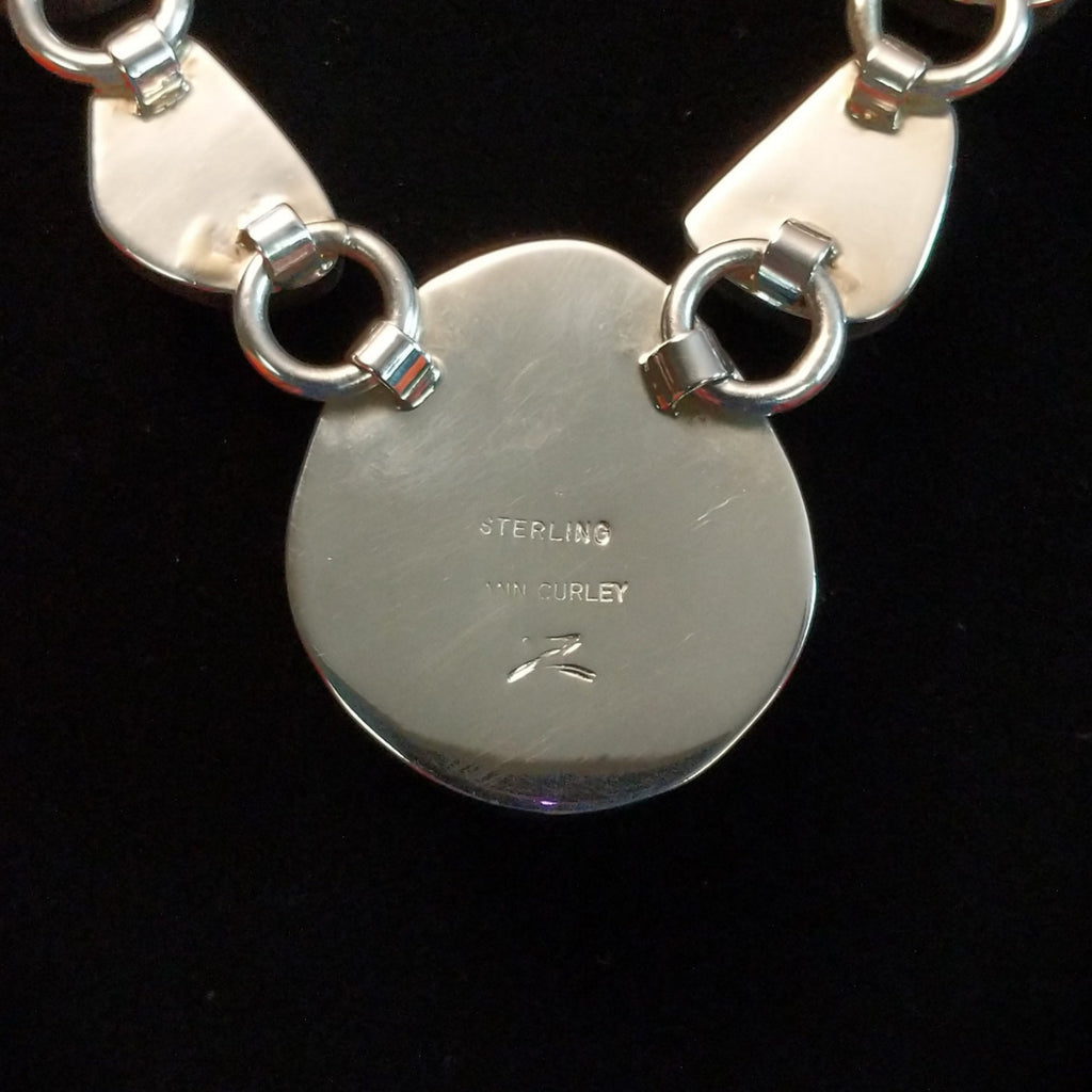 Artisan's signature stamped into the largest necklace pendant.