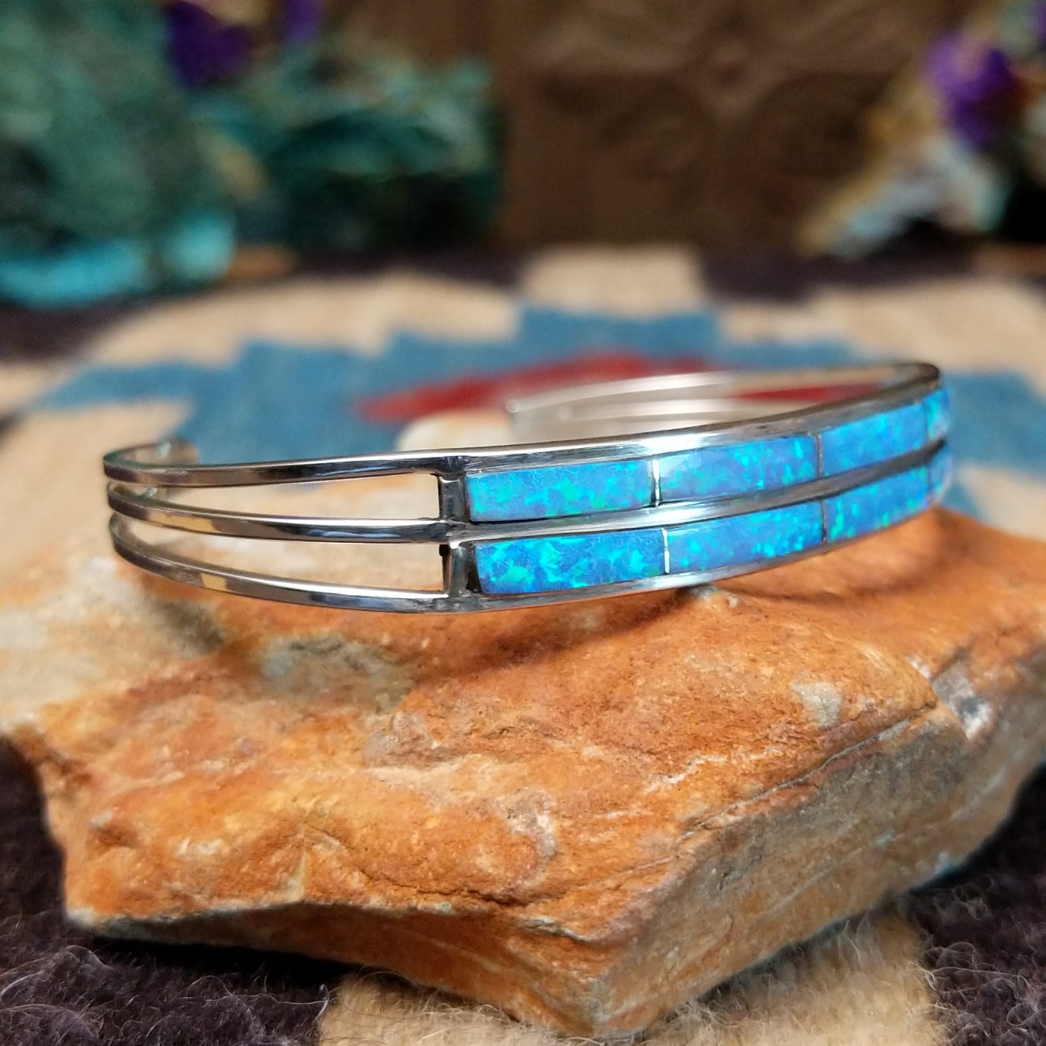 Dual row manmade opal inlay cuff by Jamie Johnson, featuring shimmering opal inlay with vibrant flashes of color set in handcrafted Southwestern-inspired metalwork.  Side view.
