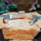 Dual row manmade opal inlay cuff by Jamie Johnson, featuring shimmering opal inlay with vibrant flashes of color set in handcrafted Southwestern-inspired metalwork.  Underside view.