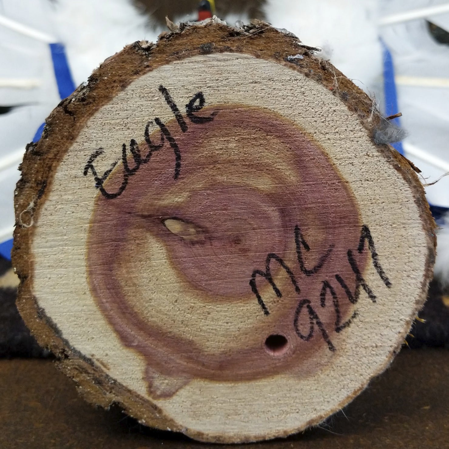 Underside of M. C. eagle dancer kachina doll showing handwritten signature and label on wood base.