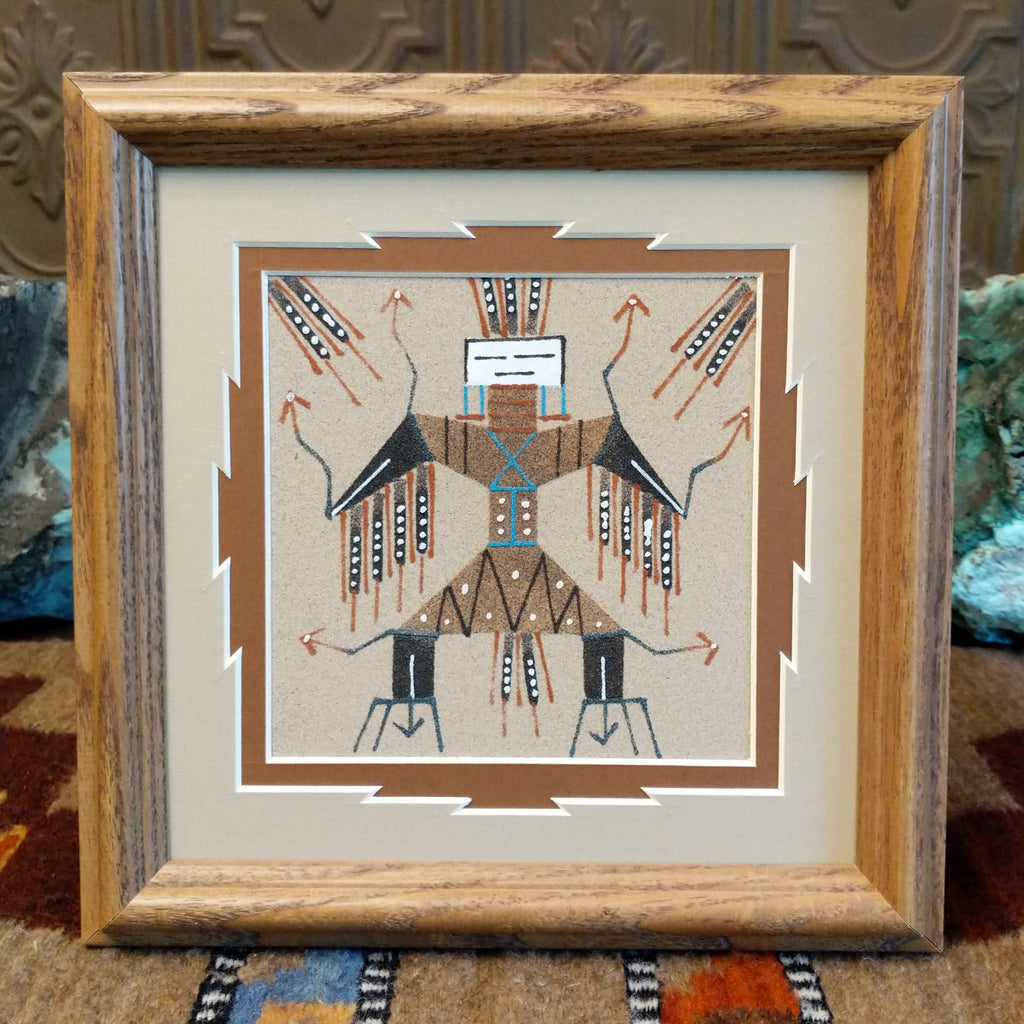 Multiple colored sands used to create an Eagle Guardian picture set within a wooden frame.