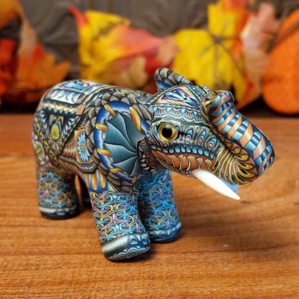 Polymer clay used to create an elephant with colorful geometric and floral designs.