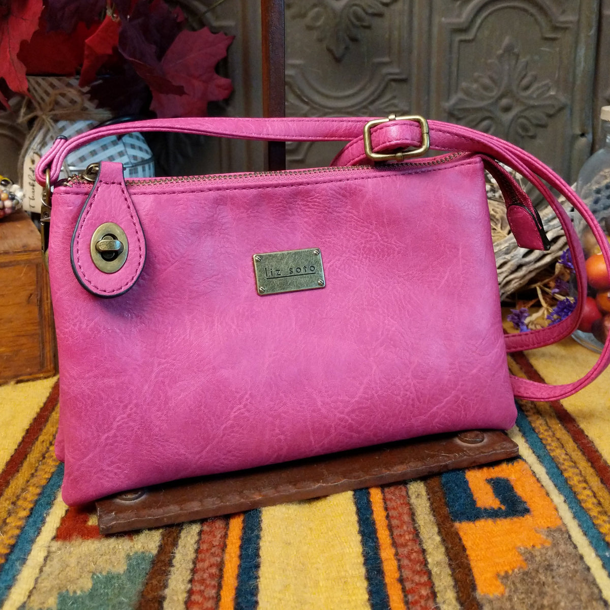 Ella Handbag by Liz Soto featuring a compact structured silhouette, textured exterior, dual handles, turn-lock accent, top zip closure, and rectangular Liz Soto logo plaque.