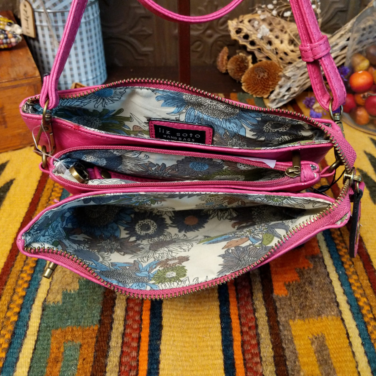 Ella Handbag by Liz Soto featuring a compact structured silhouette, textured exterior, dual handles, turn-lock accent, top zip closure, and rectangular Liz Soto logo plaque; interior view.