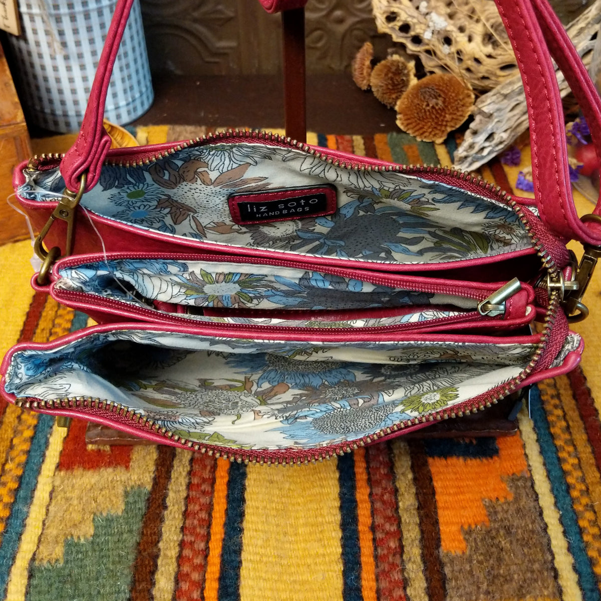 Ella Handbag by Liz Soto featuring a compact structured silhouette, textured exterior, dual handles, turn-lock accent, top zip closure, and rectangular Liz Soto logo plaque; interior view.