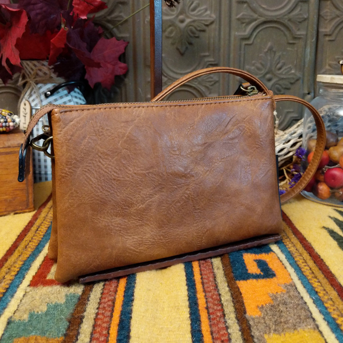 Ella Handbag by Liz Soto featuring a compact structured silhouette, textured exterior, dual handles, turn-lock accent, top zip closure, and rectangular Liz Soto logo plaque; back view.