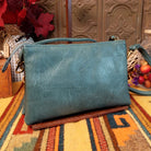 Ella Handbag by Liz Soto featuring a compact structured silhouette, textured exterior, dual handles, turn-lock accent, top zip closure, and rectangular Liz Soto logo plaque; back view.