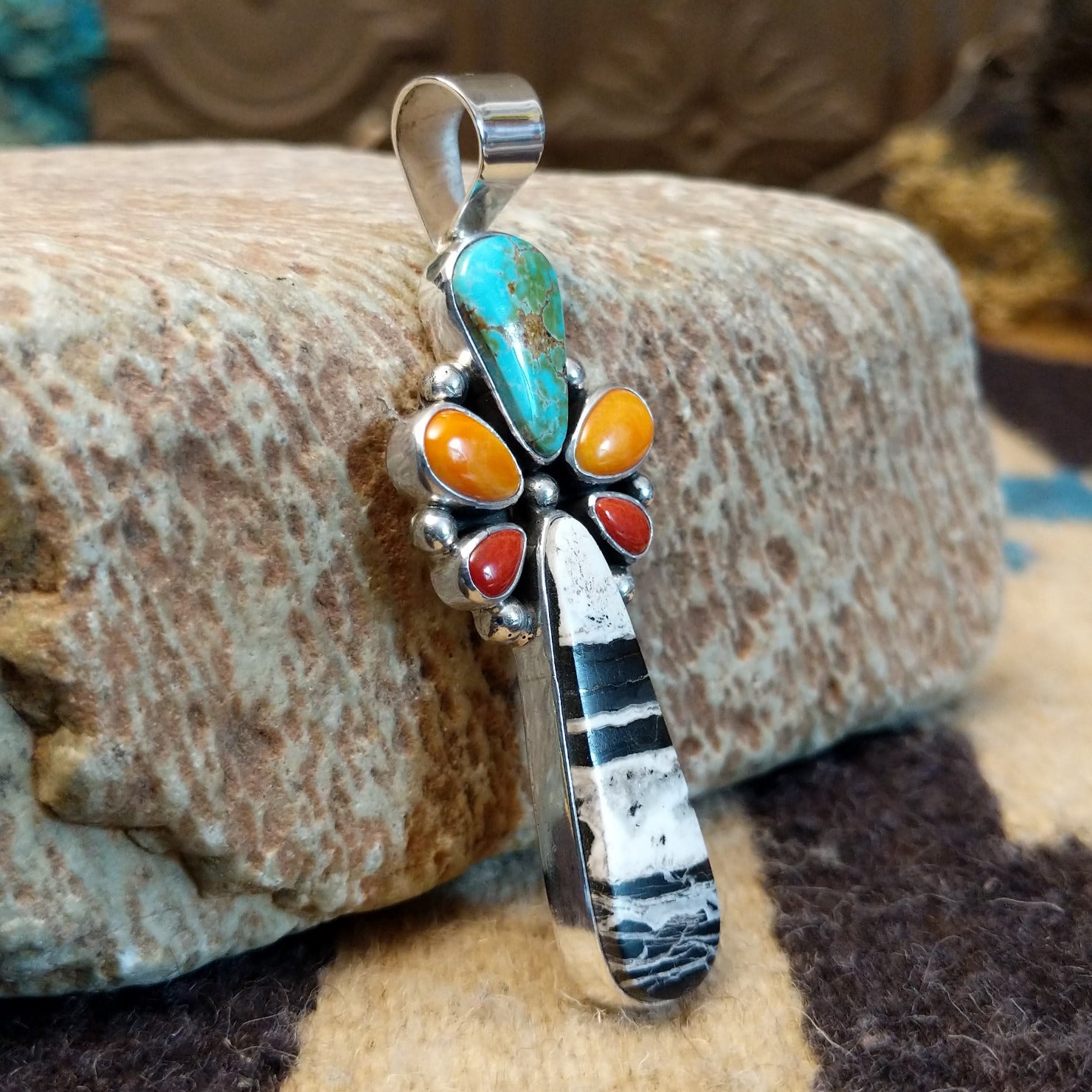 Sterling silver pendant with multiple stones set in various shaped bezels.