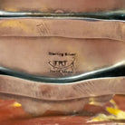Close-up of the artisan's stamped signature.