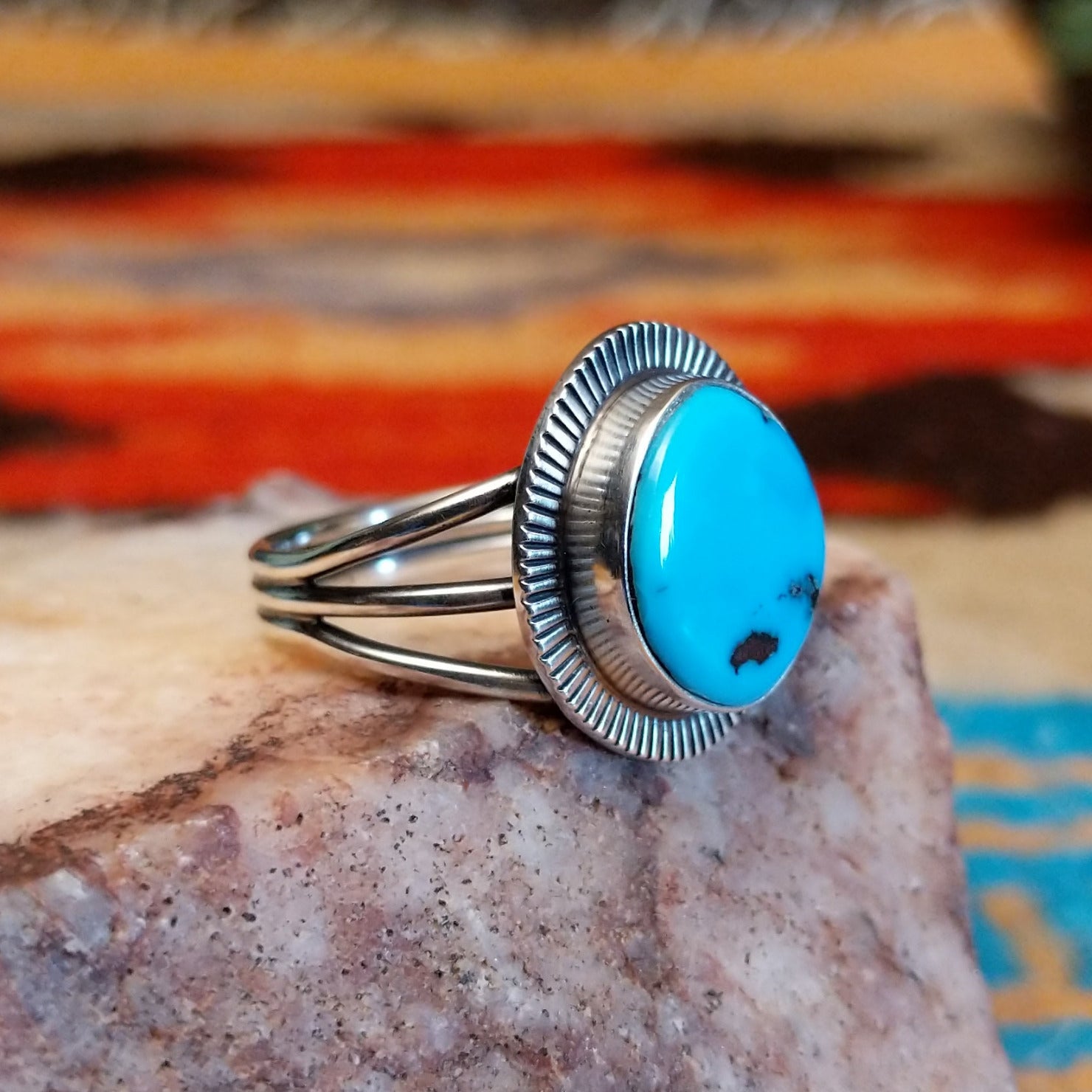 Sterling silver ring with Sleeping Beauty turquoise set in the round bezel, framed by the lined setting.