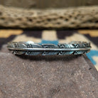 Etched silver feather cuff by Raymond Coriz, featuring a handcrafted sterling silver feather design with intricate engraved details and traditional Southwestern-inspired craftsmanship.