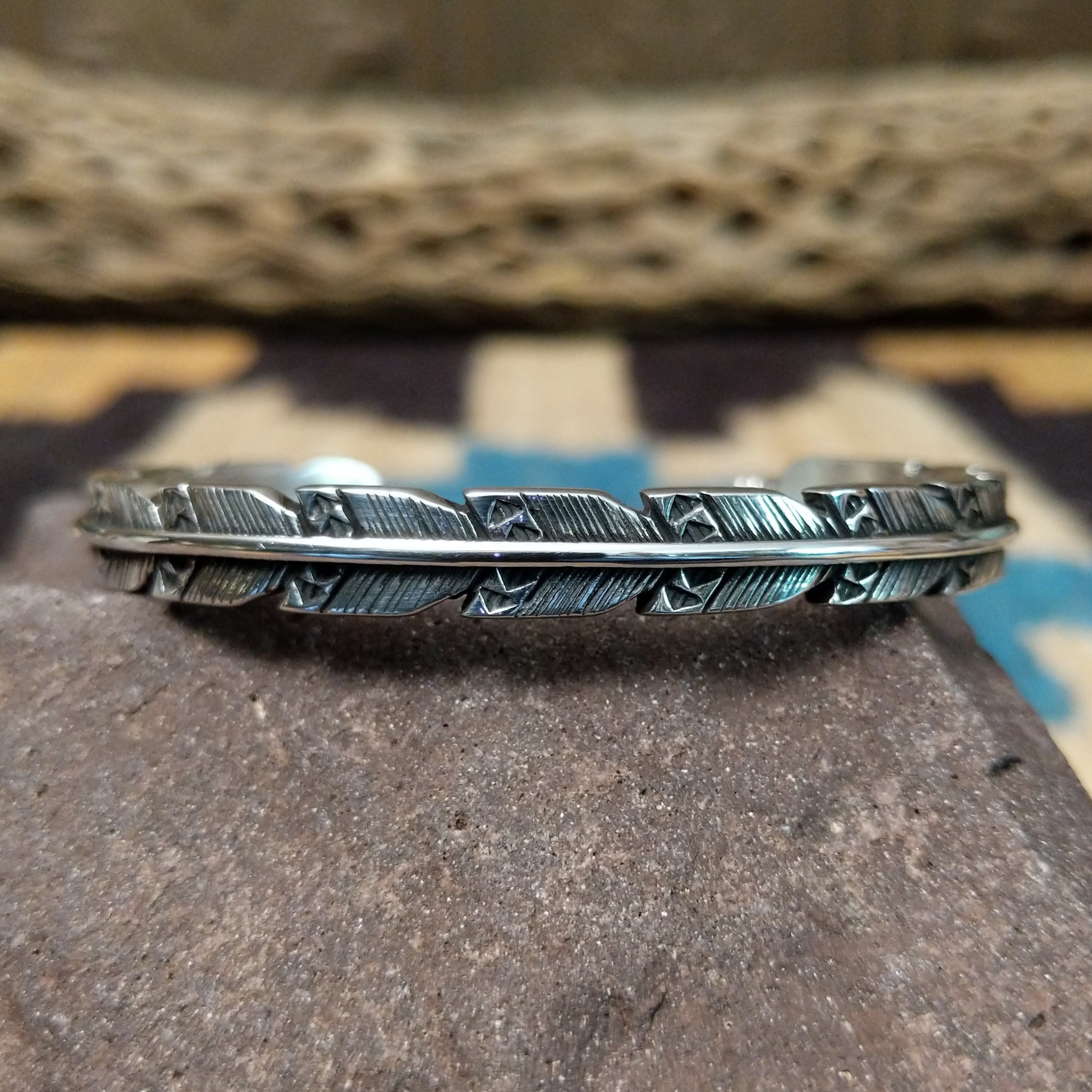 Etched silver feather cuff by Raymond Coriz, featuring a handcrafted sterling silver feather design with intricate engraved details and traditional Southwestern-inspired craftsmanship.