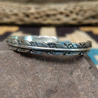 Etched silver feather cuff by Raymond Coriz, featuring a handcrafted sterling silver feather design with intricate engraved details and traditional Southwestern-inspired craftsmanship.