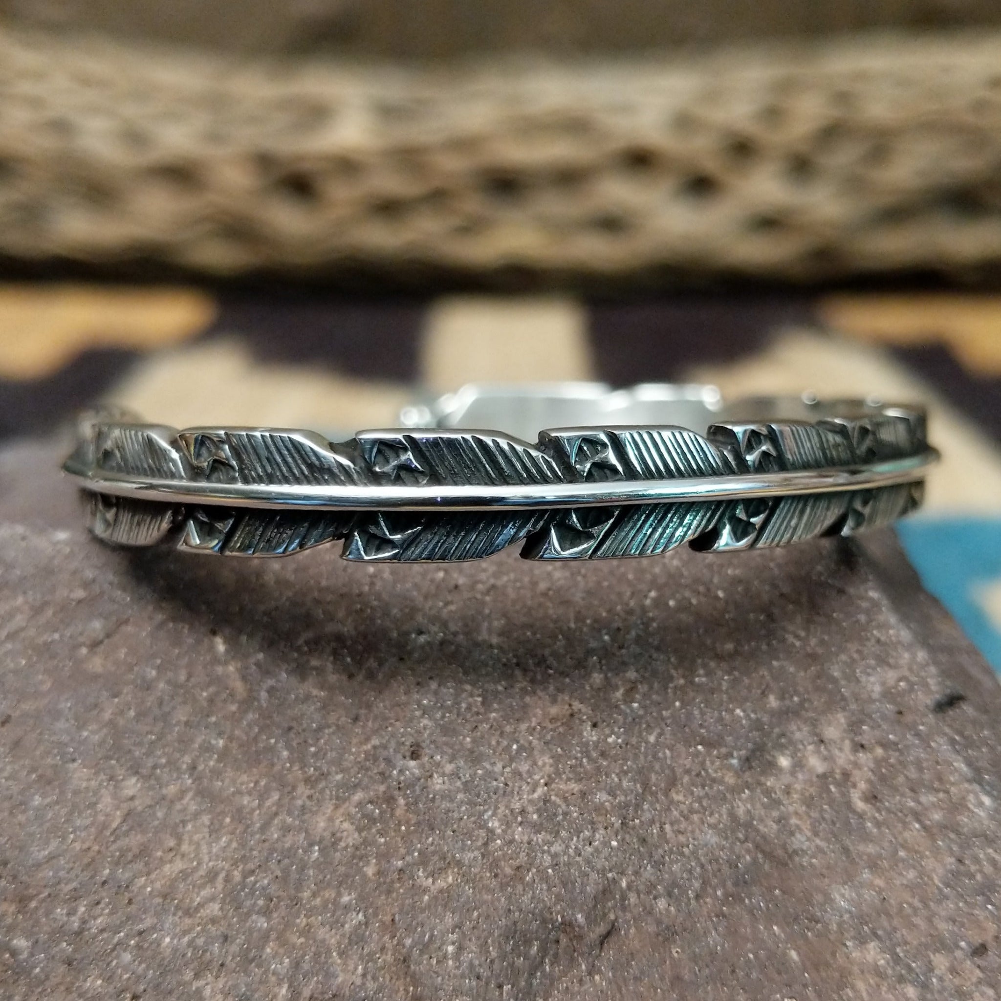 Etched silver feather cuff by Raymond Coriz, featuring a handcrafted sterling silver feather design with intricate engraved details and traditional Southwestern-inspired craftsmanship.