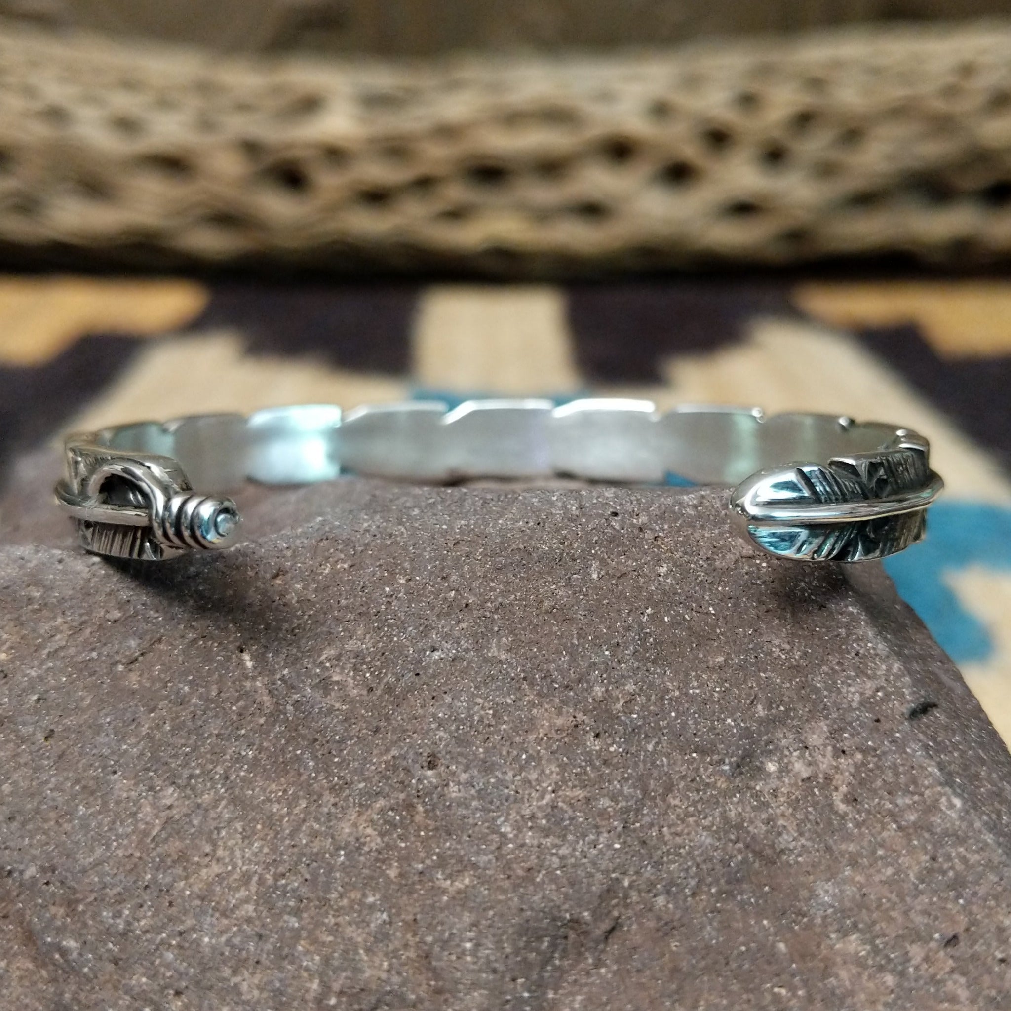 Etched silver feather cuff by Raymond Coriz, featuring a handcrafted sterling silver feather design with intricate engraved details and traditional Southwestern-inspired craftsmanship.  Underside view.