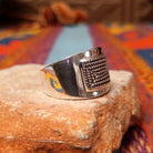 Etched Silver Ring by Raymond Coriz featuring an intricate geometric, maze-like pattern on a broad rectangular face with a polished Sterling Silver band; side view.