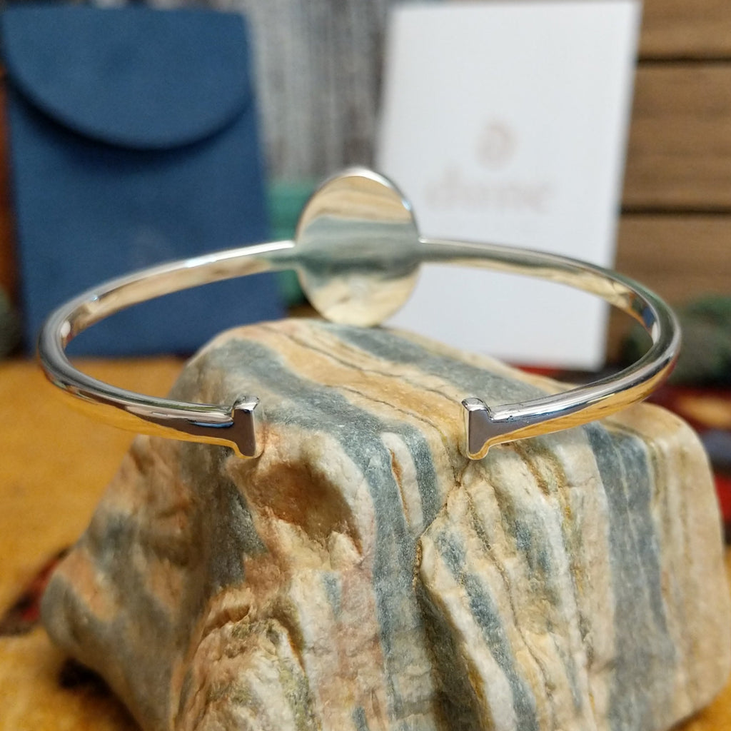 Oval cuff with a silver-plated brass band.