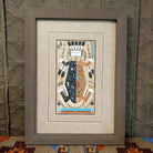 Sand used to depict Father Sky and Mother Earth in multicolored, layered sand set within a wooden frame.