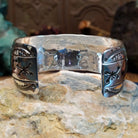 Wide sterling silver cuff bracelet with a raised leaf motif, hand-stamped details, and oxidized accents.
