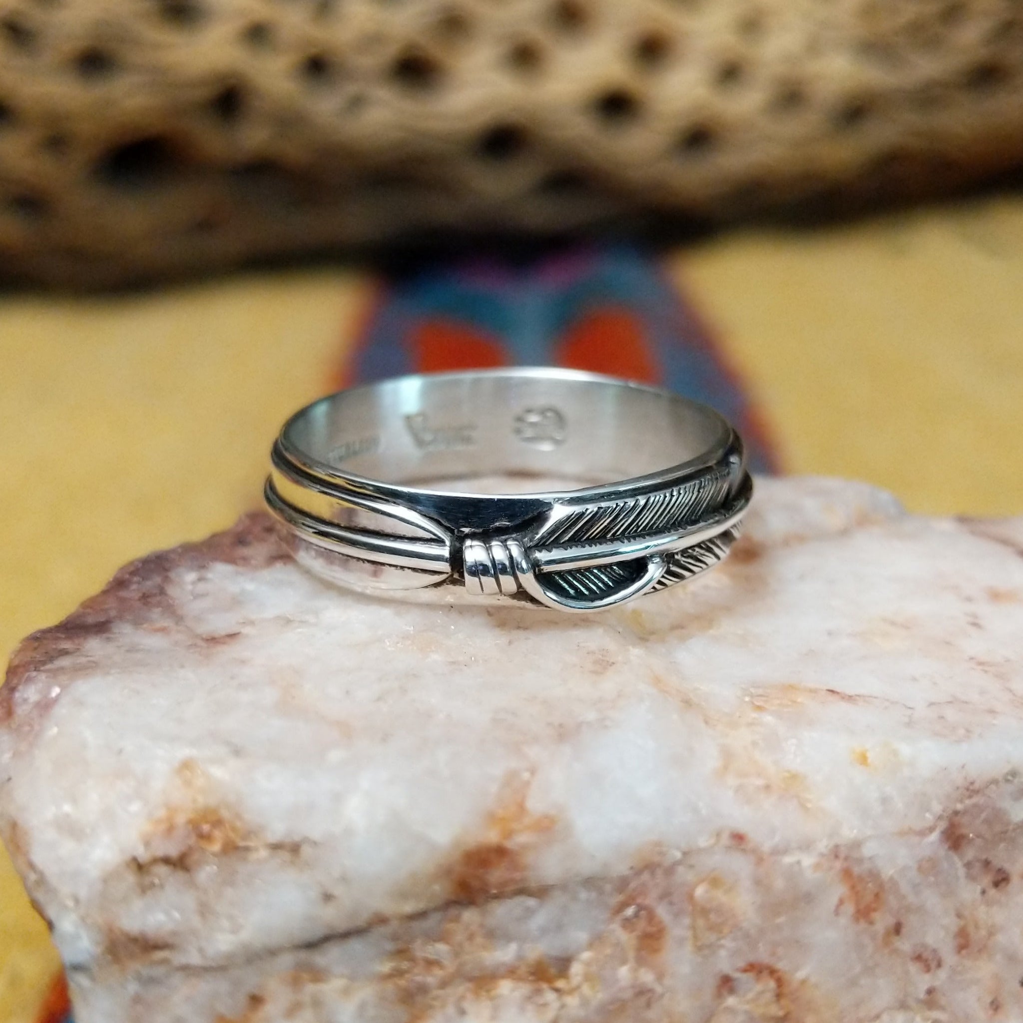 Feather loop ring by Raymond Coriz, featuring a detailed handcrafted feather design wrapped around a polished sterling silver band with traditional Southwestern-inspired craftsmanship.